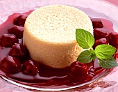 Semolina pudding with cherry sauce, garnished with mint 