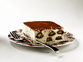 A piece of tiramisu with fork on cake plate