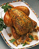 A roast chicken with herbs & chanterelle sauce on platter