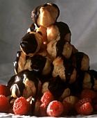 Pyramid of profiteroles with chocolate icing & raspberries