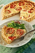 Tomato quiche, one piece on plate with lettuce