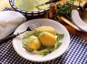 Potatoes boiled in their skins with green sauce on plate