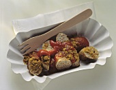 Curry sausage, cut up, in paper dish with cocktail stick
