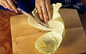 Cutting up cabbage (removing thick midribs before cooking)