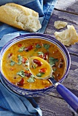 A bowl of kidney bean soup with peppers and coriander leaves