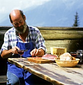 S. Tyrolean farmer enjoying afternoon snack of bacon & red wine