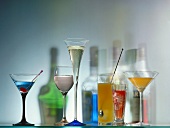 Bunte Cocktails in Gläsern & Farbschatten von Flaschen