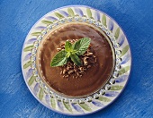 Chocolate blancmange in glass dish, with mint garnish