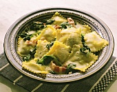 Ravioli mit Spinat, Speck & Sahnesauce auf Teller