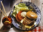 Hamburger on plate with salad and a drink