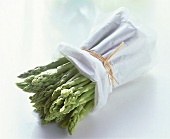 A bundle of green asparagus wrapped in white paper