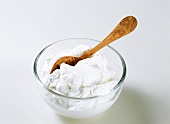 Quark in glass bowl with wooden spoon