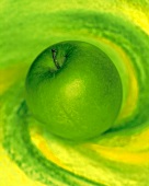 Ein Granny-Smith-Apfel auf grün-gelbem Untergrund
