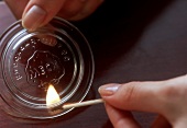 The Lid of a Glass Jar with Lit Match