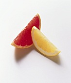 Pink and yellow grapefruit wedge on white background