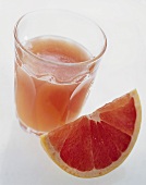 Red Grapefruit Juice in a Glass with Grapefruit Wedge