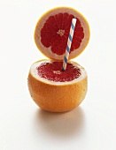 Rosa Grapefruit mit geöffnetem Deckel und Trinkhalm