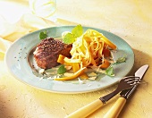 Peppered steak with vegetable pasta on plate