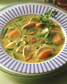 Vegetable soup with chicken breast in soup plate