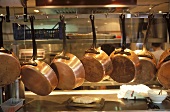 Kupferpfannen hängen einer Stange in der Grossküche