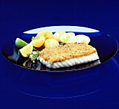 Cod fillet au gratin with potatoes on plate