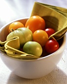 Various tomatoes on cloth in white bowl