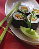 Gemüse-Sushi und Stäbchen auf weisser Servierplatte