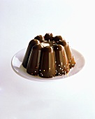 Turned-out chocolate pudding decorated with silver balls