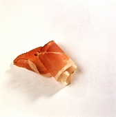 A thin slice of bacon, rolled up