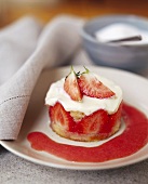 Small strawberry tartlet with strawberry sauce on plate