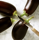 Aubergines, some of green on stalk removed with a knife