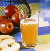 A glass of naturally cloudy apple drink & fresh apples