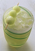 Melon drink, cocktail stick with melon balls on top