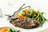 Grilled steak with vegetables on plate