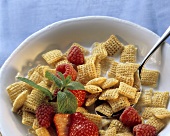 A dish of cereal flakes, strawberries and raspberries