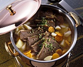 Boiled meat, broth and vegetables in pot