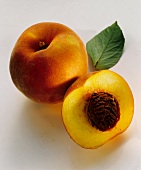 Pfirsich & Pfirsichhälfte mit gelbem Fruchtfleisch