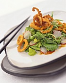 Breaded cuttlefish rings on mixed salad