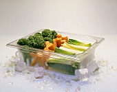 Gefrorenes Gemüse in Behälter mit Eis