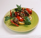Grilled lamb kebabs with tomato wedges on plate
