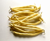 Several wax beans against white background