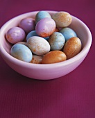 Colourful eggs in a white bowl
