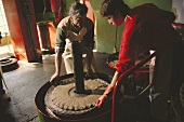 Workers spreading olive pulp on pressing mats