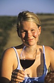 Sommerabend im Weinberg: Frau hält ein Glas mit Rotwein