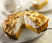 Lemon meringue pie, pieces cut, one piece on cake slice