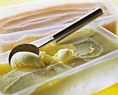 Vanilla icecream with scoop & papaya icecream in plastic bowls