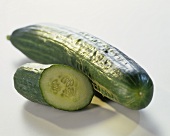 Whole cucumber, a small piece of cucumber beside it