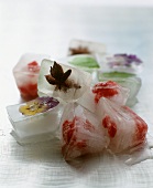 Ice cubes with fruit and flowers frozen in