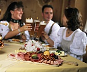 Junge Leute mit Bier und Brotzeitplatte im Gasthof (Andechs)