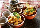 Two bowls of potato curry with red lentils